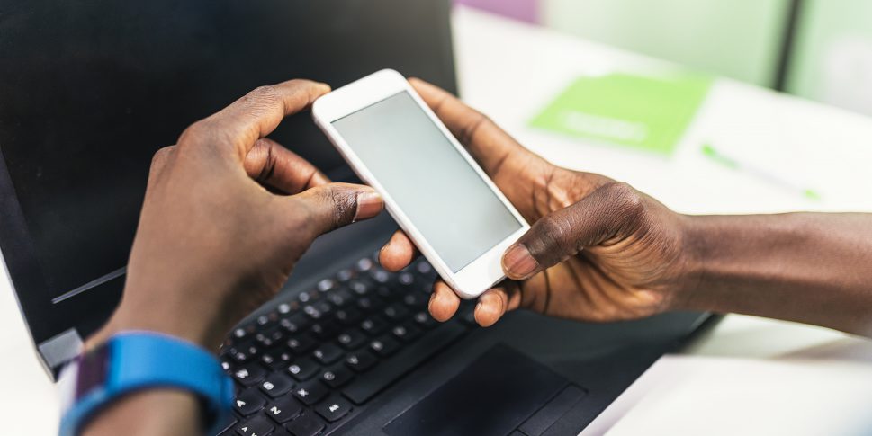 Close up of black hands using mobile.